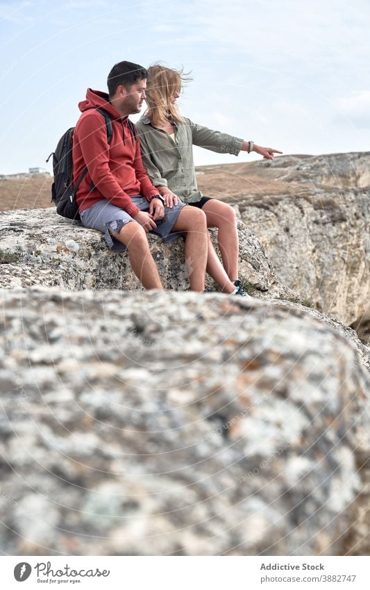 Traveling couple resting on hill during trekking travel hiker rocky mountain relax explorer together nature landscape tourism vacation relationship highland