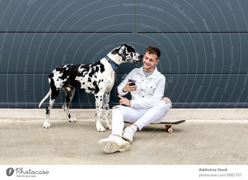 Man taking selfie with dog on street man great dane self portrait smartphone friendship together friendly companion gadget device animal mobile city smile