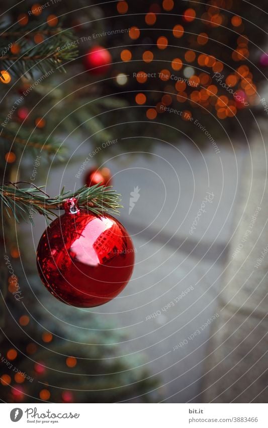 Red christmas tree ball, hanging from the christmas tree, on christmas market, in front of shiny bokeh. Christmas & Advent Christmas decoration Christmas tree
