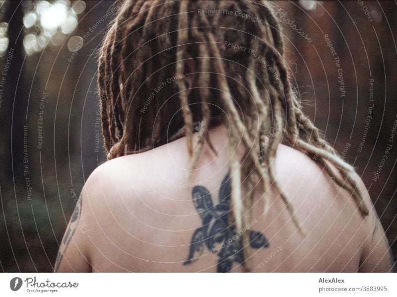 Portrait of a young woman with dreadlocks and tattoos in the forest Woman Dirty Blonde tattooing Jewellery Piercing earring Concealed Direct Nahe Skin