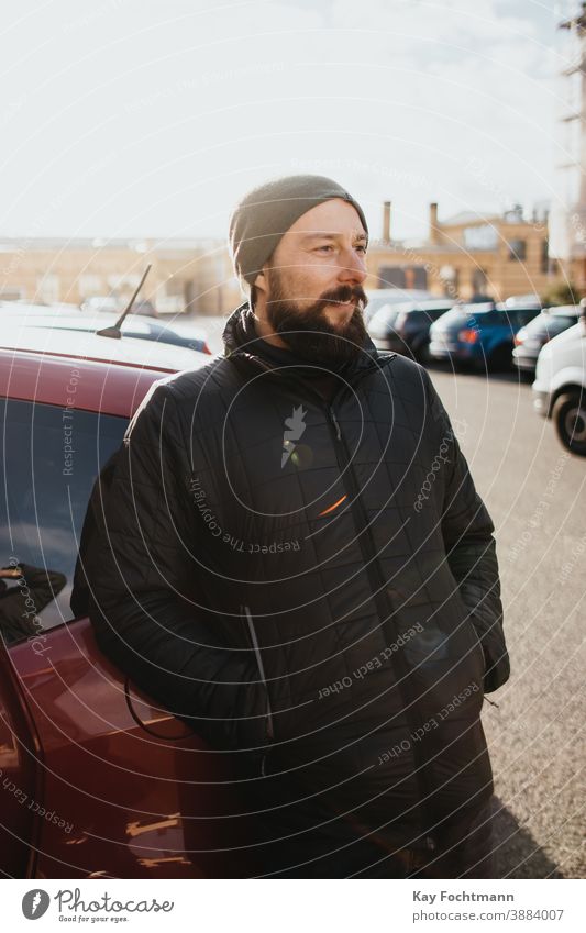 smiling bearded man dressed in winter clothes adult attractive car caucasian cheerful city clothing cold enjoying exterior fashion fashionable freedom frost