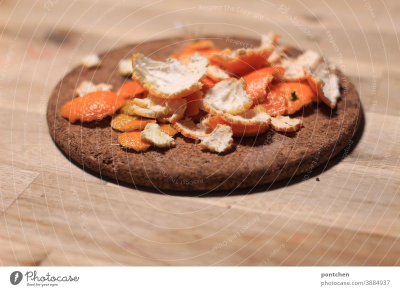 Tangerine shells lie on a cork coaster on a wooden table. Winter. Vitamin c mandarins peeled fruit Fruit Vitamin C salubriously Nutrition Table Cork Healthy