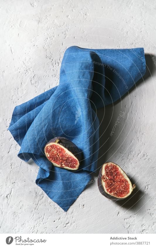 Tasty fig on napkin on table half fruit delicious healthy food fresh sweet treat exotic tropical ripe yummy dessert nutrition vitamin organic desk piece natural