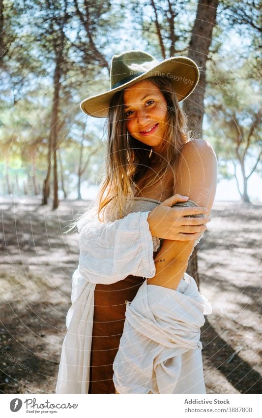 Carefree woman enjoying nature in forest carefree freedom wind sunlight gentle hippie female hipster hat top peaceful woods summer serene young tender harmony