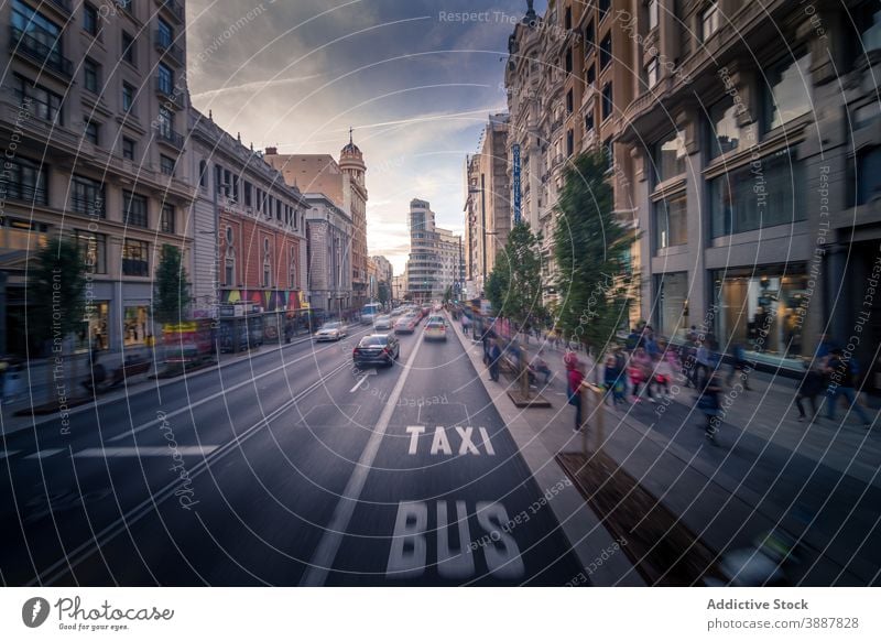Road in city in evening traffic road pavement people car cityscape roadway active speed madrid spain sidewalk building motion street twilight district urban