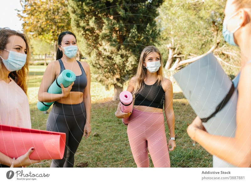 Young women in masks preparing for yoga class in park group coronavirus together active practice instructor pandemic covid covid 19 covid19 wellness