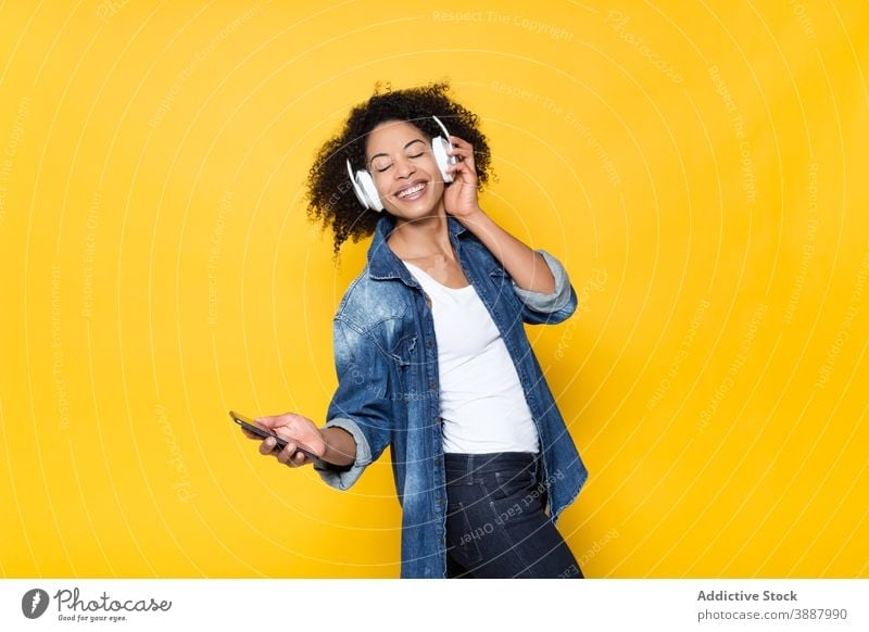 Happy black woman listening to music with headphones cheerful wireless smartphone happy having fun hipster enjoy young african american ethnic optimist