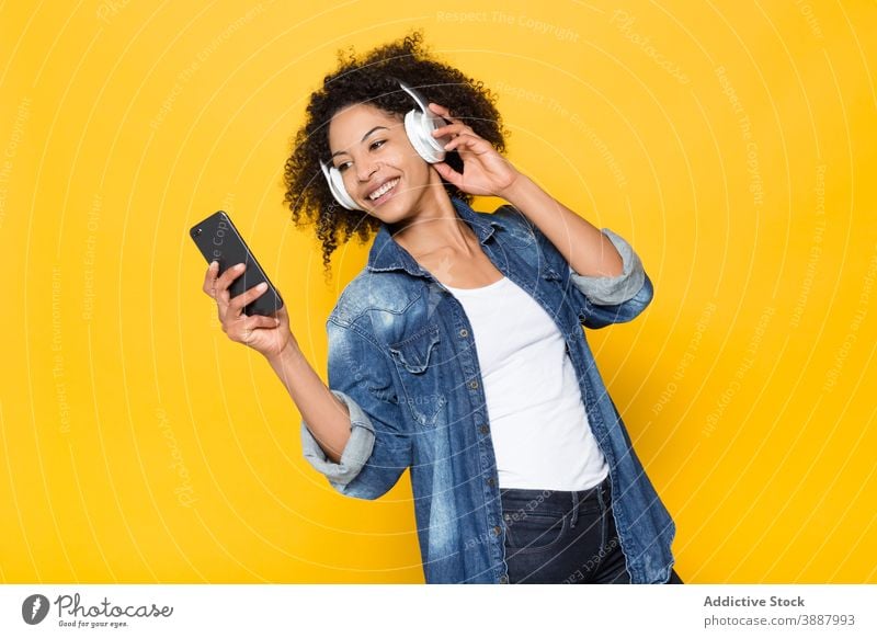 Happy black woman listening to music with headphones cheerful wireless smartphone happy having fun hipster enjoy young african american ethnic optimist