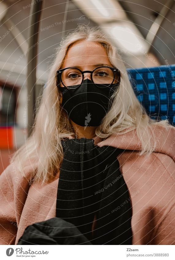 Young woman sitting in the train with a corona mask coronavirus Blonde long hairs Track voyage Company Winter Coat Eyeglasses Fashion style Looking pretty