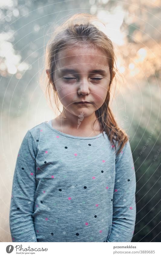 Sad little girl with closed eyes standing in smoke back to sunlight child kid portrait sunshine thought sadness childhood Child cute Infancy Sadness Cute Small