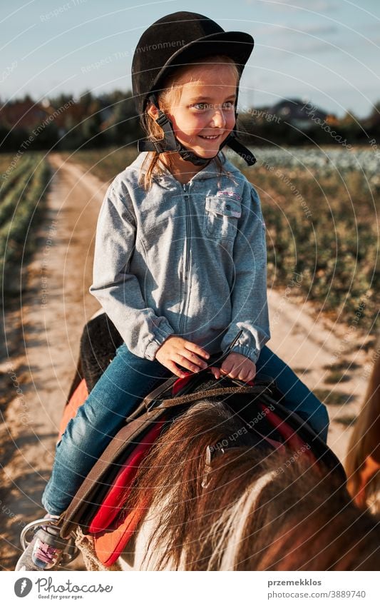 Little smiling girl learning horseback riding kid ride practice school cute country pretty rural ranch lesson rider happiness countryside active equestrian