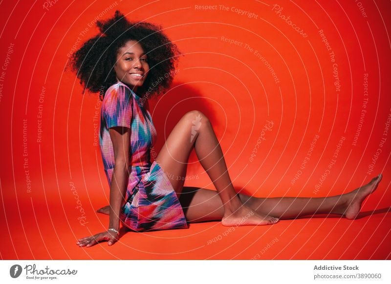 Charming black woman in vivid dress in studio cheerful bright laugh colorful trendy fun fashion toothy smile millennial ethnic afro african american cuban