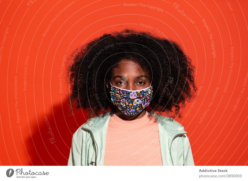 Black woman in protective mask in studio prevent textile fabric human face emotionless hairstyle pandemic contemporary bright ethnic covid19 covid 19