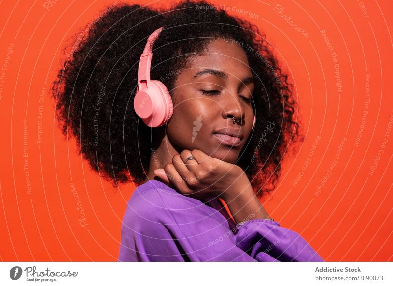 Emotionless African American woman in headphones music vivid listen style emotionless unemotional cool model millennial sound trendy female afro ethnic