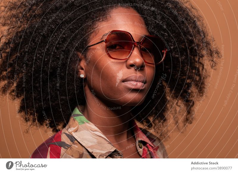 Trendy black model in sunglasses woman exotic ornament trendy cuban studio posture floral ethnic hairstyle african american afro cool eyes closed human face