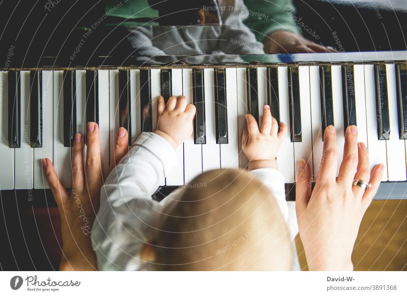 Mother and child make music together at the same time Make music Child Musical instrument early musical education Parenting Family Playing Piano hands in common