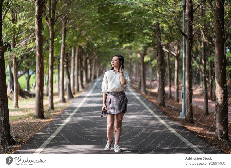 Young Asian woman walking in urban park coquette carefree summer charming entertain female ethnic asian tanya shen green bikeway taichung taiwan optimist young