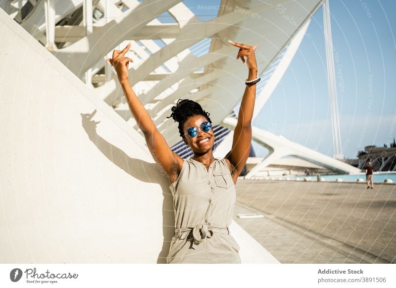 Happy black woman showing middle fingers on street fuck gesture rude sign symbol rebel female ethnic african american cool sunglasses happy style smile urban