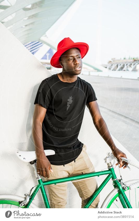 Stylish black man with bicycle in city urban style young bike modern trendy confident male ethnic african american street appearance hipster serious hat cool