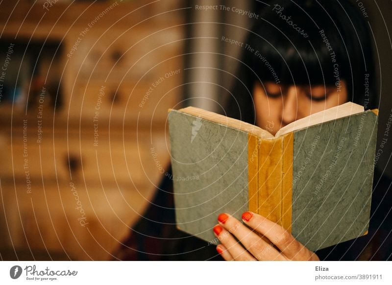 A woman reads a book Reading Book at home Woman Novel Old Reading matter hollowed browse books Diary Notebook Literature youthful Cozy by oneself
