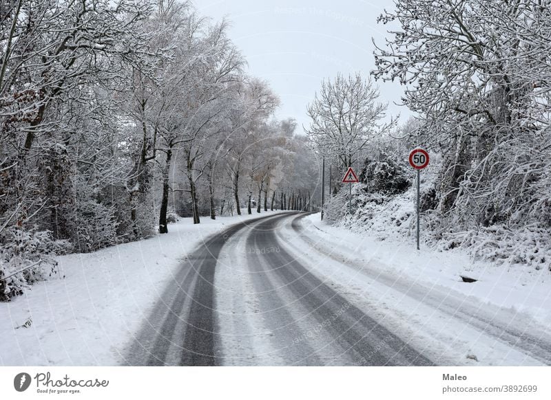 Dangerous turn on a slippery snowy road in winter dangerous cold forest travel white path asphalt nature landscape way wood icy country countryside journey