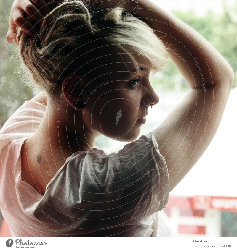 diagonally from behind Style Young woman Youth (Young adults) Head Hair and hairstyles Arm 18 - 30 years Adults T-shirt Piercing Earring Blonde Long-haired