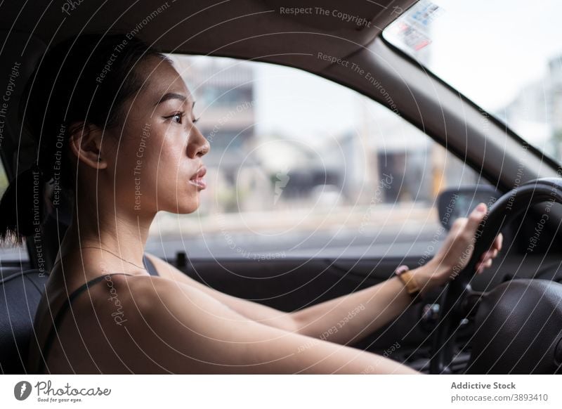 Ethnic woman driving car in city drive driver road concentrate focus auto automobile female ethnic asian taichung taiwan modern urban young contemporary vehicle