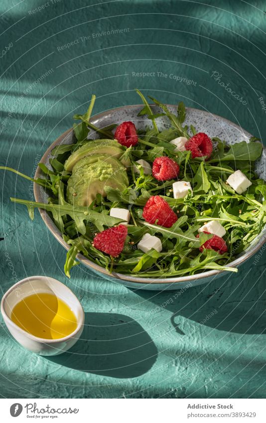Healthy salad with green leaves and berries healthy arugula avocado raspberry cheese fresh food bowl delicious oil meal cuisine serve nutrition organic