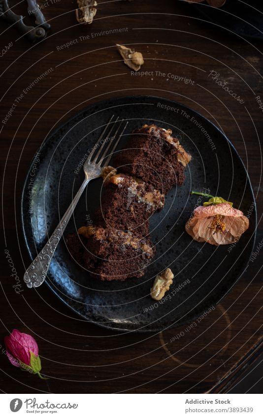 Yummy chocolate cake on black plate piece walnut flower serve dessert sweet food fork pastry naked cake rustic layer gourmet confectionery sophisticated