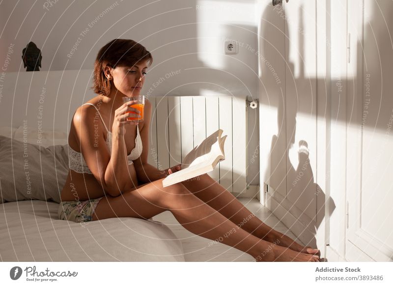 Serene pregnant woman reading book in morning pregnancy bed home literature expect female tranquil relax rest peaceful cozy soft glass juice comfort sit drink