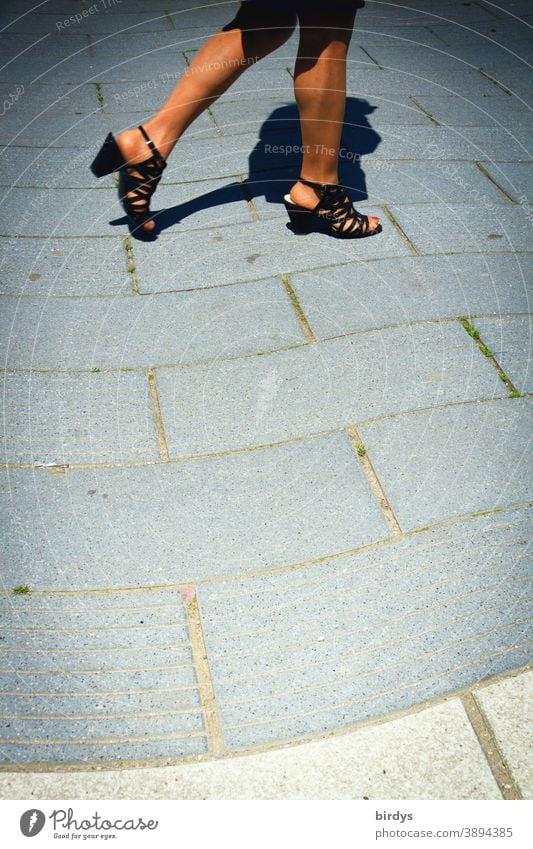 Woman with slim , tanned legs walks on a wavy paved path Legs Slim Lifestyle Going Summer Warmth Sandals naked legs Movement Floor covering Sunlight Naked flesh