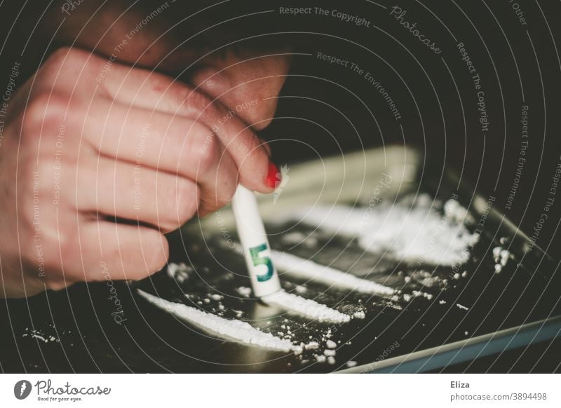 A woman consumes a white line in powder form with a rolled banknote through her nose drug use coke white powder Pull Nose Bank note Rolled Line Woman