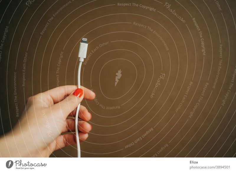 Woman holding a charging cable in her hand charger cable Load Cellphone power supply iPhone Cable Energy battery Recharge Connector smartphone Hand stop