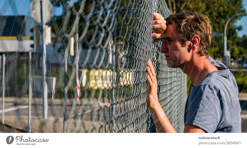 Sad Caucasian Man Leaning Head Against Fence portrait sad man sadness 1 person outdoor real life real person male profile side view state of mind emotion