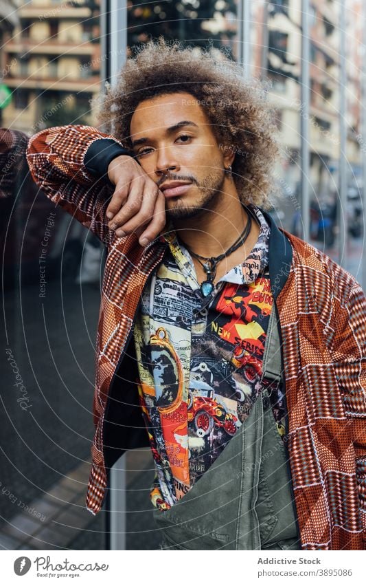 Stylish ethnic hipster man in trendy clothes style urban modern curly hair beard fashion young male african american black apparel lifestyle street handsome