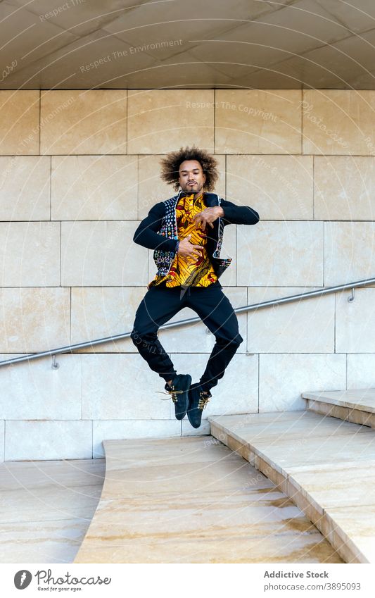 Stylish hipster man jumping on stairs energy trendy style step high informal young guy above ground african american black ethnic dynamic male modern leap