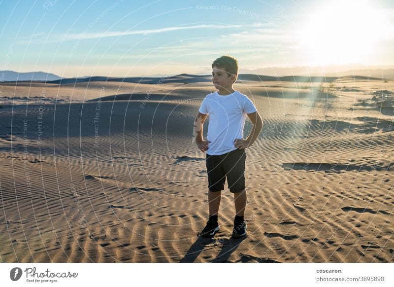 Little boy looking away in the desert arid beach casual caucasian child clear dry dune ecology enjoy enjoyment environment fun happy holidays hot kid landscape