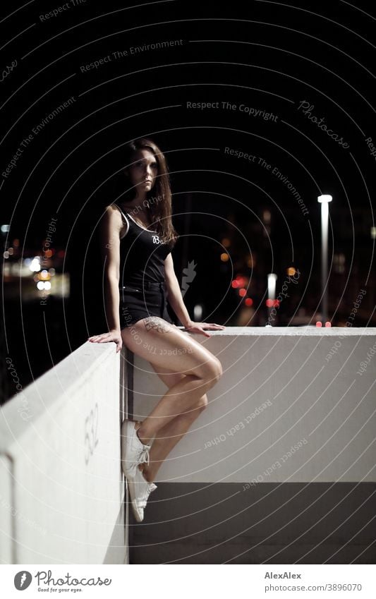Portrait of a young woman on a white wall in front of city lights at night Woman Young woman portrait out Town City lights Night Night life Night mood Nahe