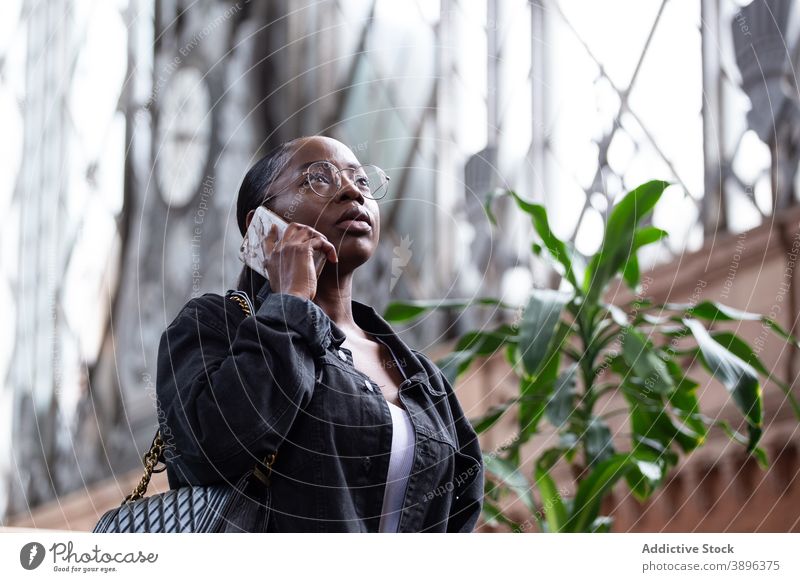 Black woman talking on smartphone on street serious communicate urban conversation listen speak young female african american black ethnic gadget device call