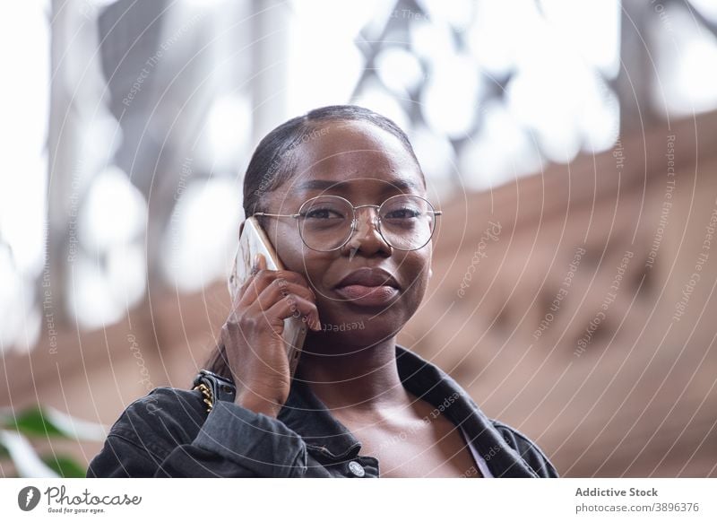 Black woman talking on smartphone on street serious communicate urban conversation listen speak young female african american black ethnic gadget device call
