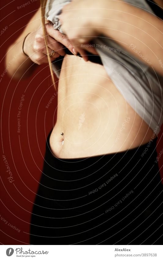 Picture of a trained, fit female abdomen with sixpack and navel piercing daintily Jewellery Copy Space left Close-up Feminine portrait Shallow depth of field