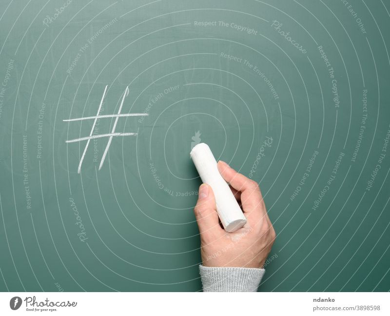 female hand drawn hashtag symbol in white chalk on green chalk board business network blogger internet share communication media promotion online marketing