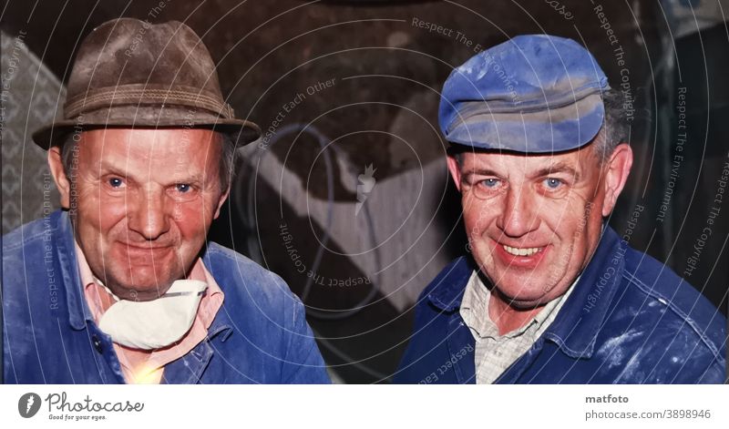 Two happy grandfathers at work. Blue overalls Cap Mask labour Hut