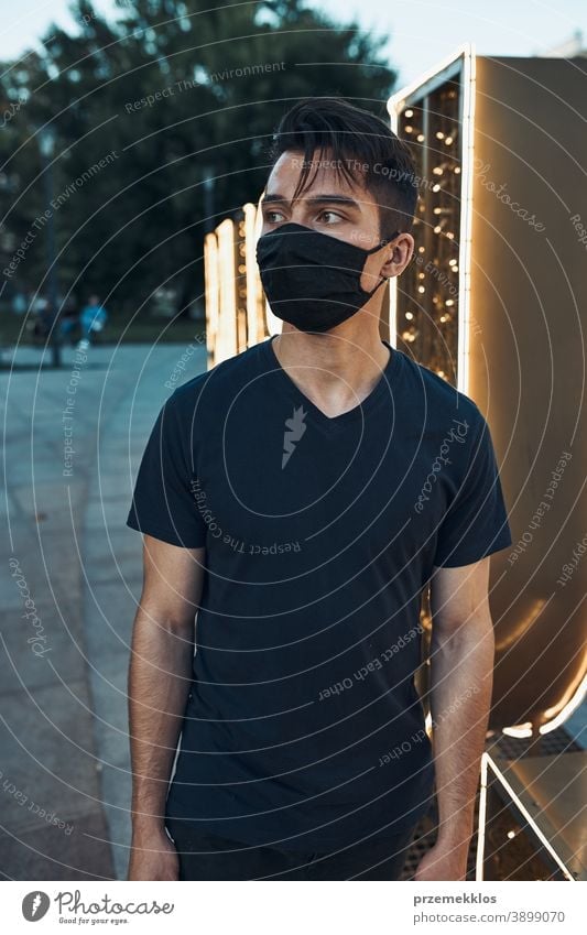 Young man standing in the city center wearing the face mask to avoid virus infection boy care caucasian contagious conversation corona coronavirus cover
