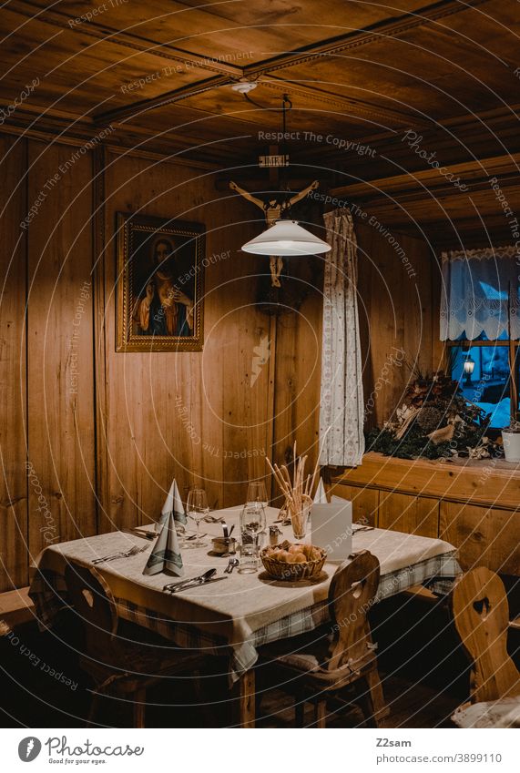 Holzstube mit gedecktem Tisch in traditionellem Ambiente ambiente holzstube gedeckter tisch essen restaurant hütte bayern südtirol österreich gemütlich wärme