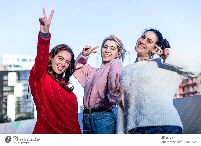 Front view of three Teenage girls making a peace sign outdoors in a sunny day victory Sign Caucasian Cheerful Cute Expression Friendship Happiness Lifestyle