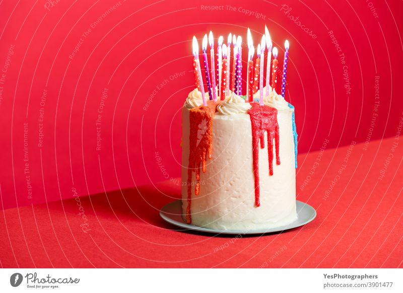 Birthday cake with candles on a red background. Festive buttercream cake anniversary birthday cake candlelight celebrating celebration colorful comfort food