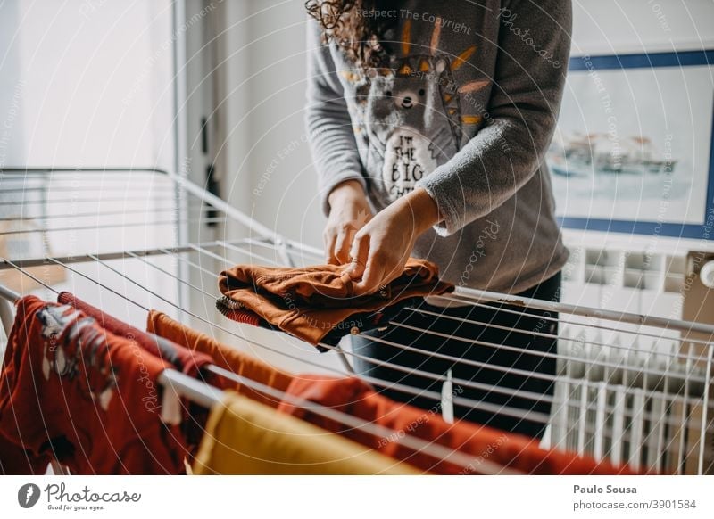 Woman drying clothes indoor Clothesline clothes horse indoors Domestic domestic life house Household Housekeeping Mother motherhood at home Laundry