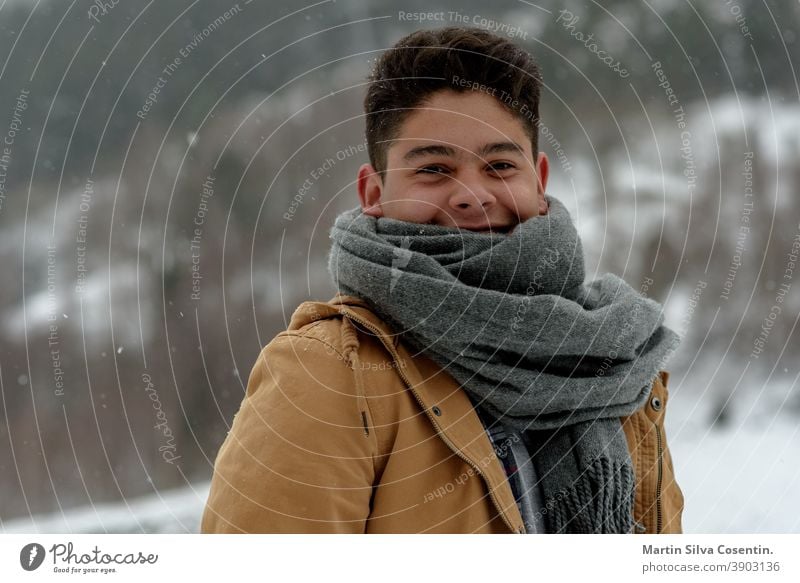 Young man smiling in the snow in Andorra seasonal confident freedom modern trendy resort leisure natural pose posture relax sexy confidence jacket traveling