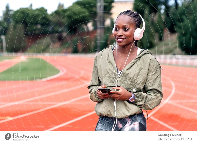 Athlete sprinter sitting listening to music smartphone afro concentration technology cell cellphone helmet mobile athlete ethnic afroamerican track train